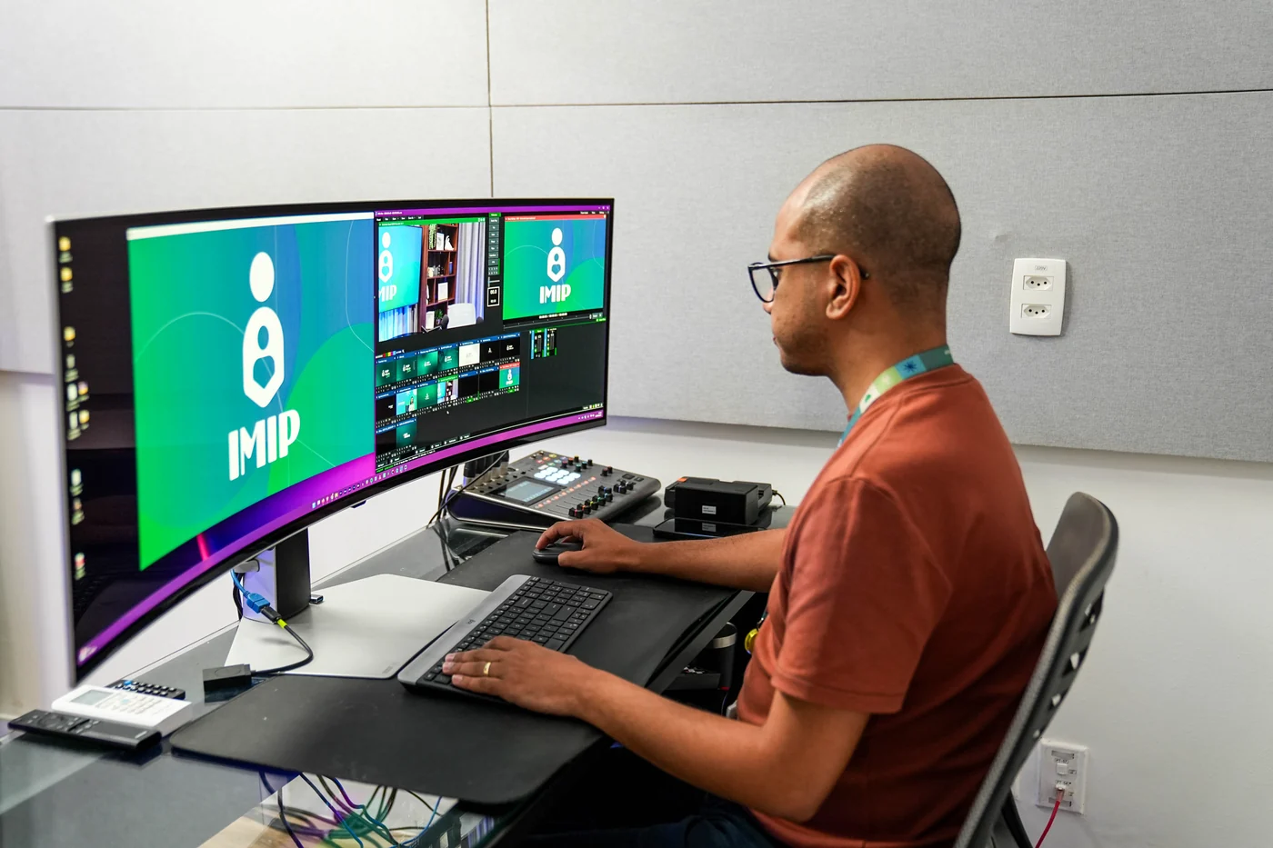 Profissional audiovisual operando a ilha de gravação do IMIP Estúdio